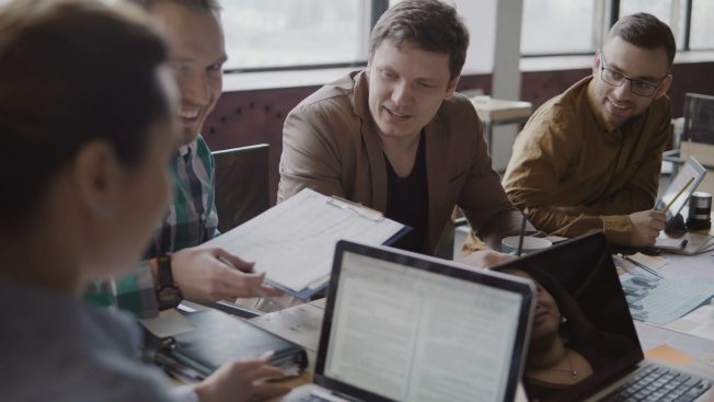 A group of individuals smiling and talking to each other.